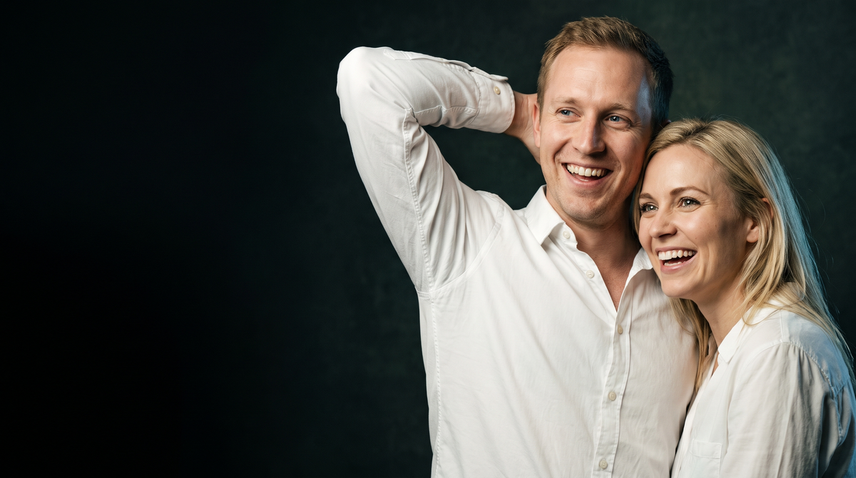 A couple laughing in crisp white shirts, his raised arm showing a spotless underarm